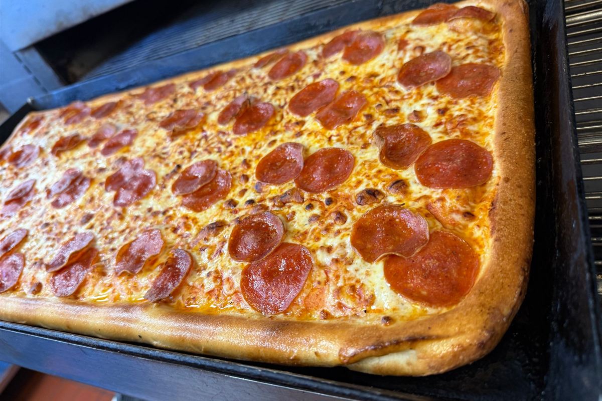 Real 32-slice Gigante pepperoni pizza coming out of the oven at PizzaLoca
